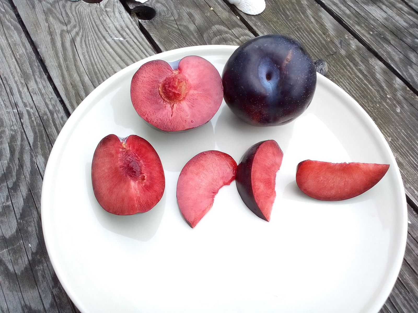 Pluot fruit, whole and halved